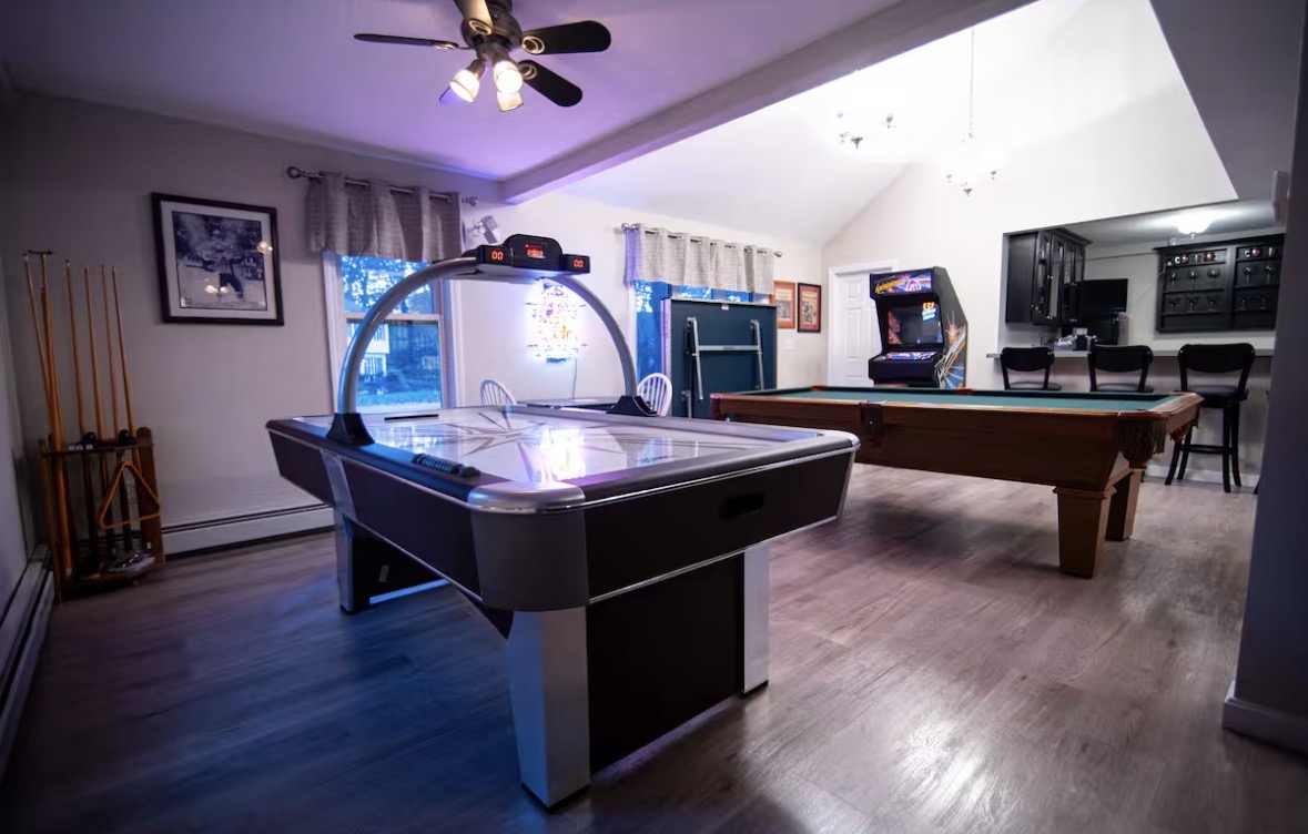 Lake house game room with air hockey, pool, and arcade games